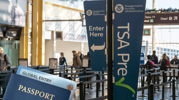 Passport with Global Entry card in front of TSA Pre-Check lane entry
