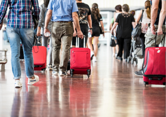 People in airport pulling red suitcases People in airport pulling red suitcases